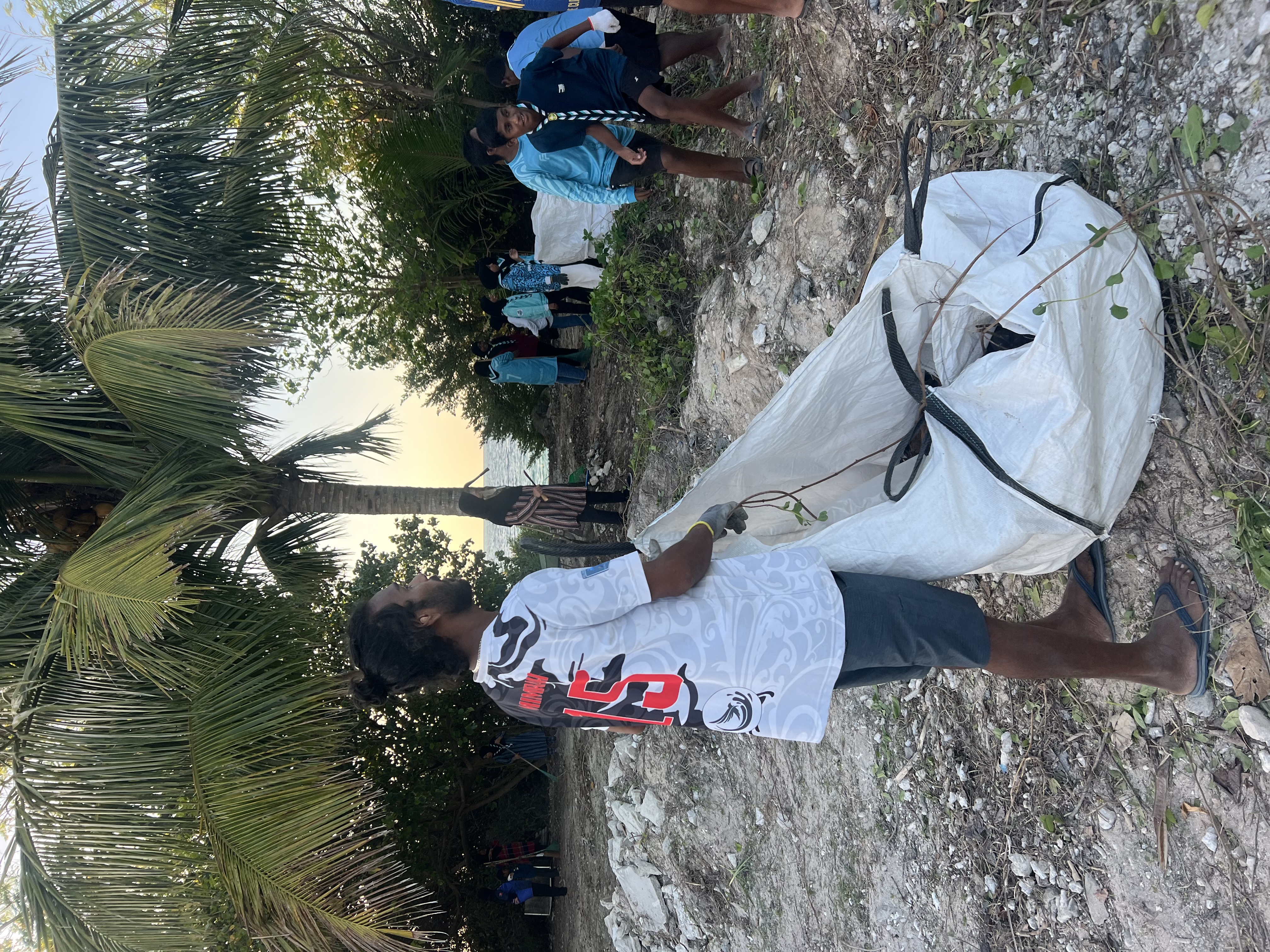 A bag of collected plastic being dragged across the sand