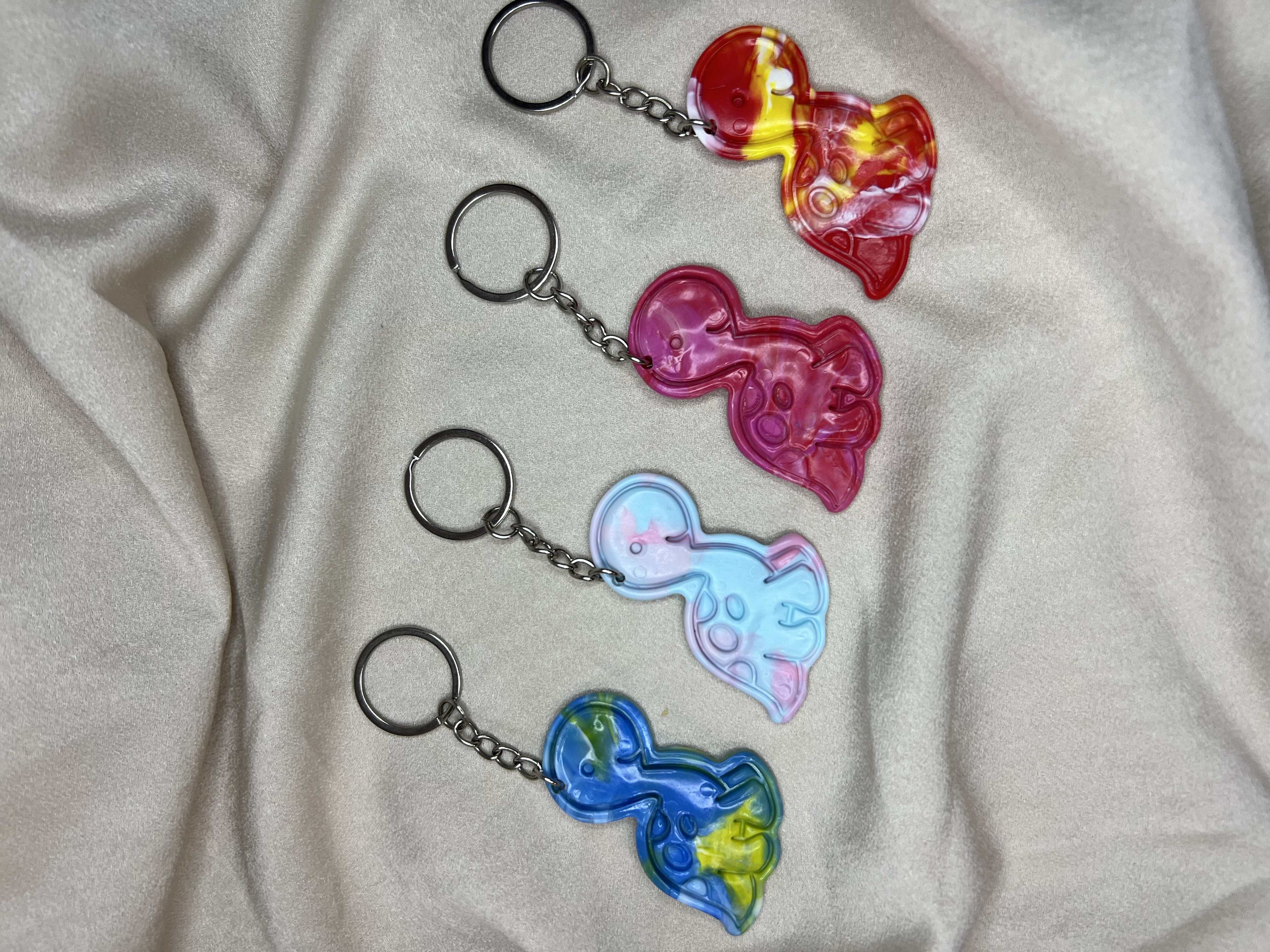 Four colourful dinosaur keychains