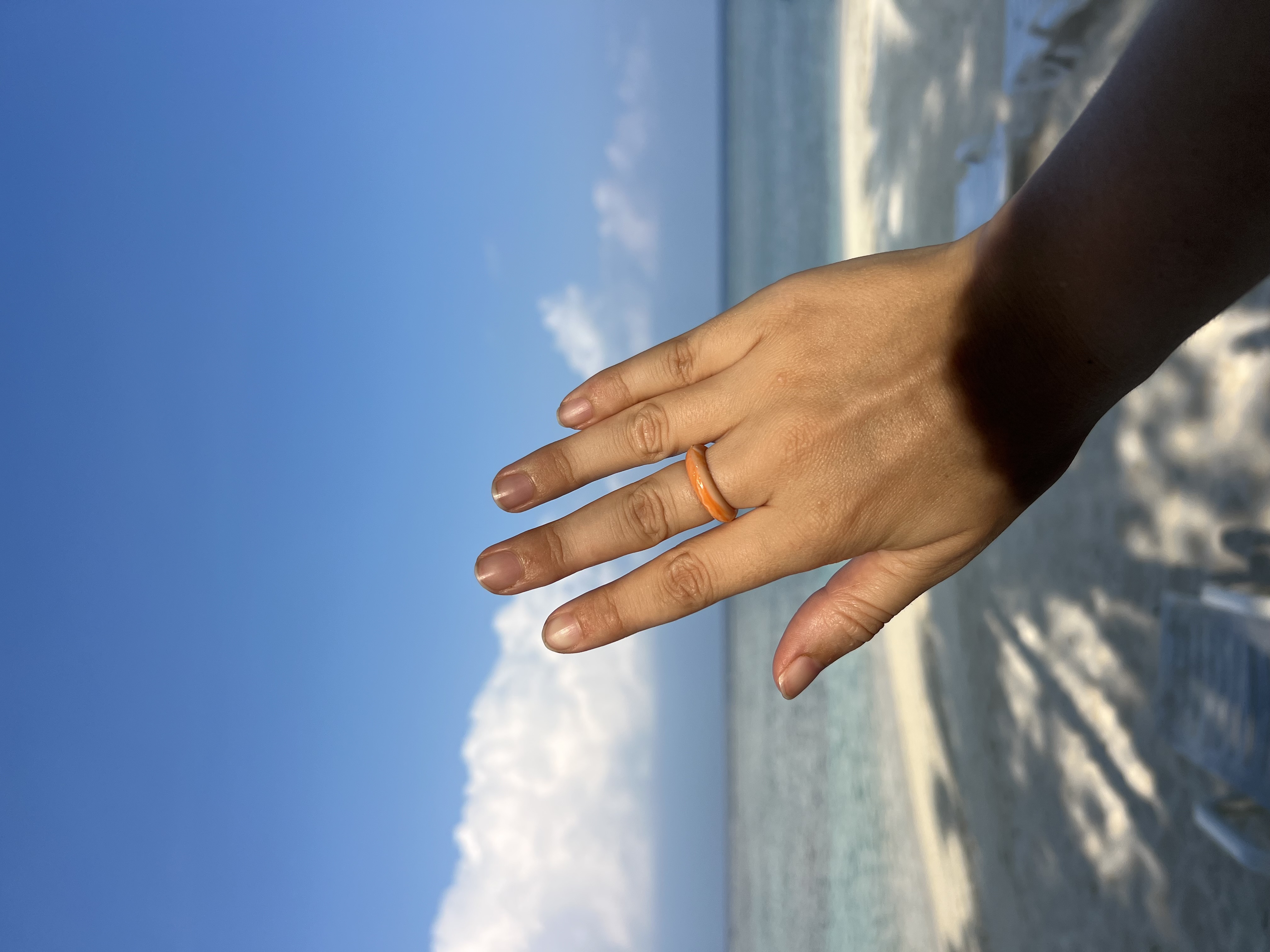 Peach coloured recycled plastic ring on a beach